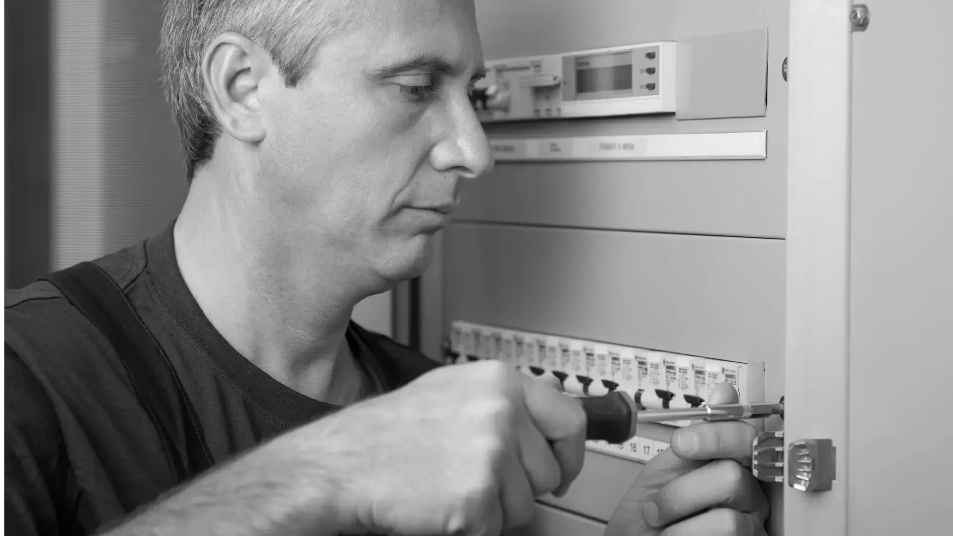 Electrician wiring a new breaker into an open electrical panel